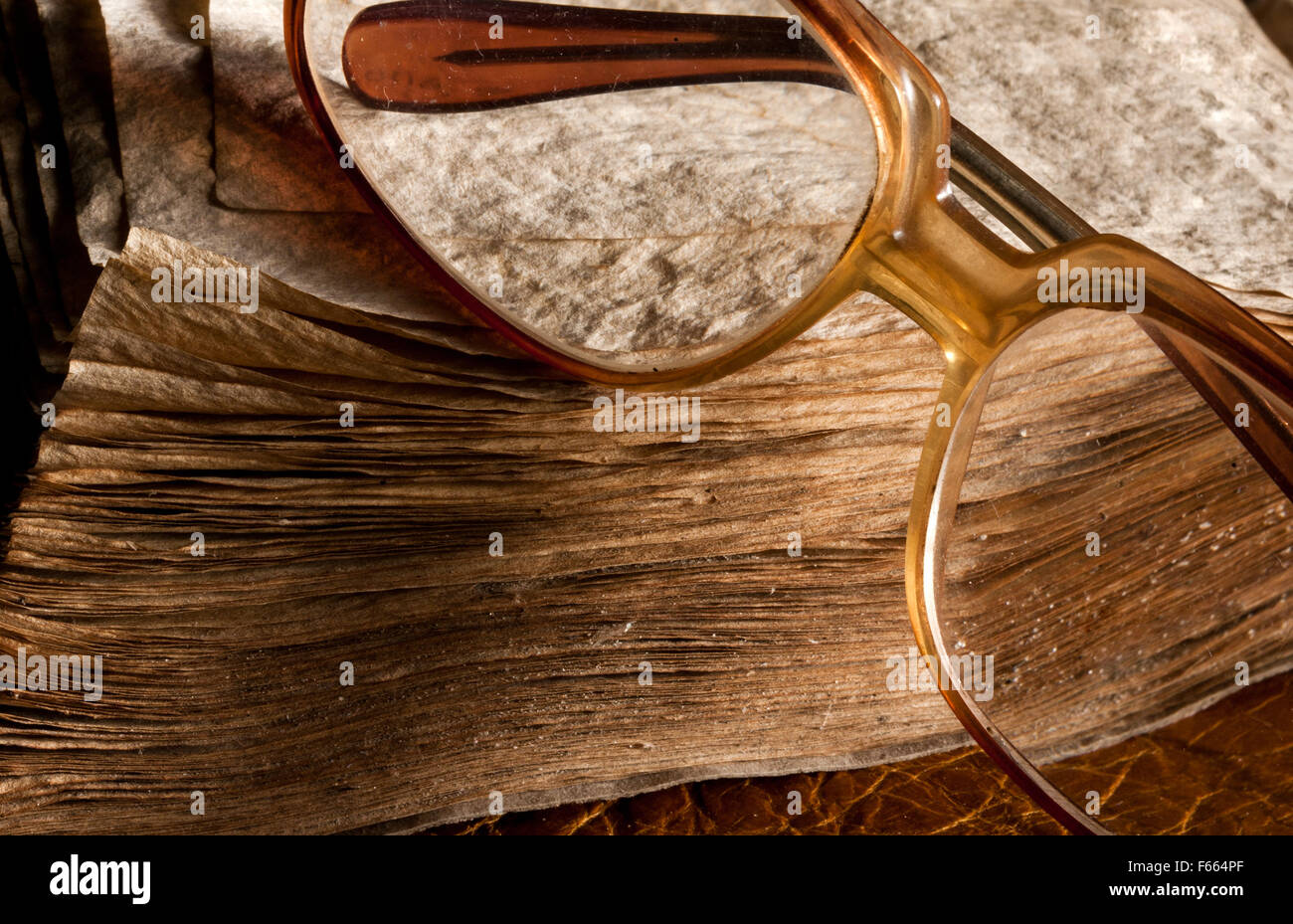 Antique glasses on old weathered book. Close-up view Stock Photo