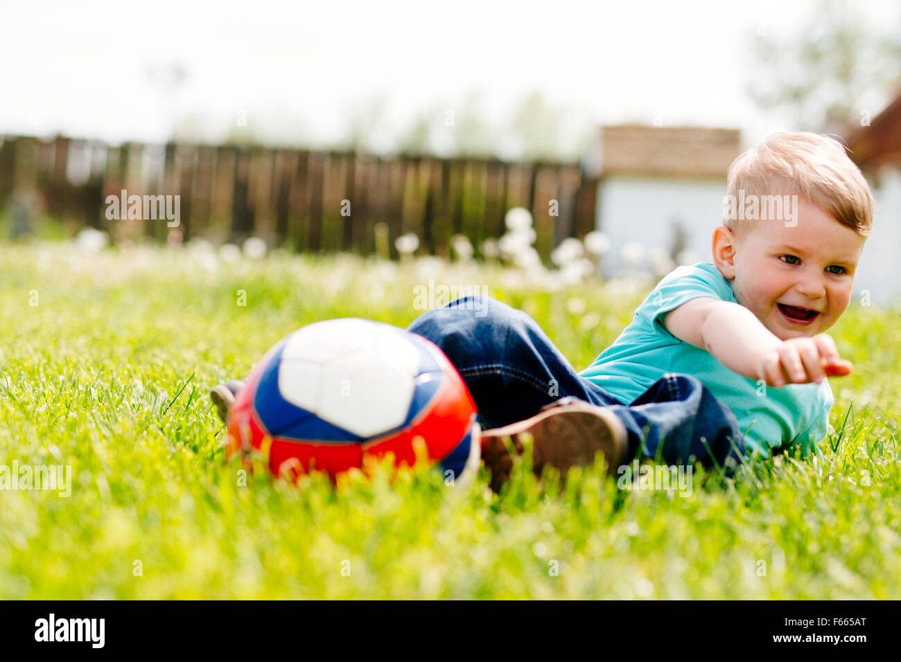 Adorable small boy playing with a soccer ball outdoors Stock Photo