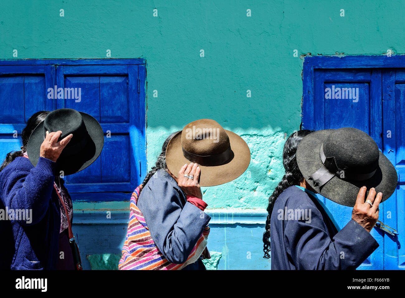 Andean women in procession under the sun Stock Photo