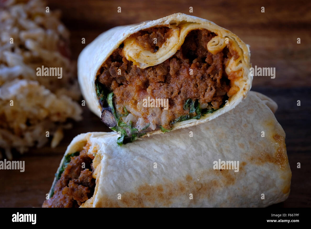 Beef burritos rolled in flour Tortilla with black bean spread served with Mexican rice Stock Photo