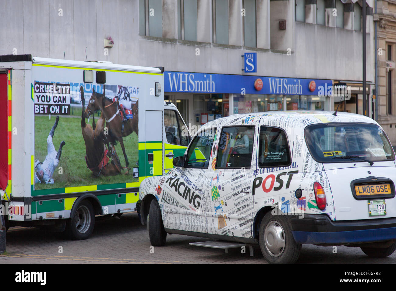A anti horse racing campaign vehicle next to a taxi promoting betting on horse racing in Chaltenham, Gloucestershire, England Stock Photo
