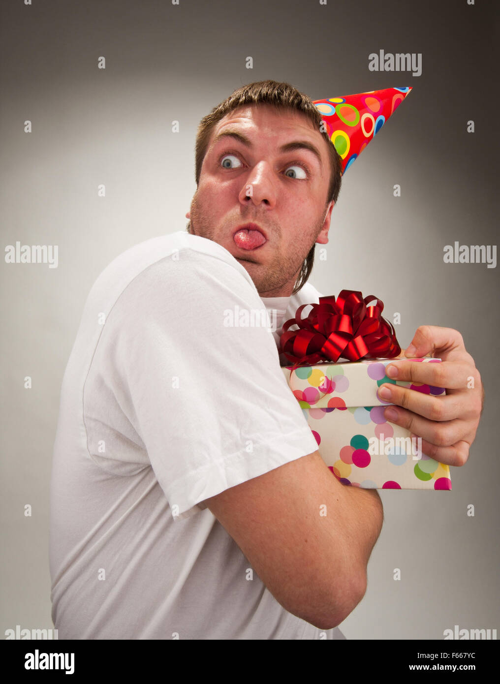 Funny birthday man with gift making face Stock Photo