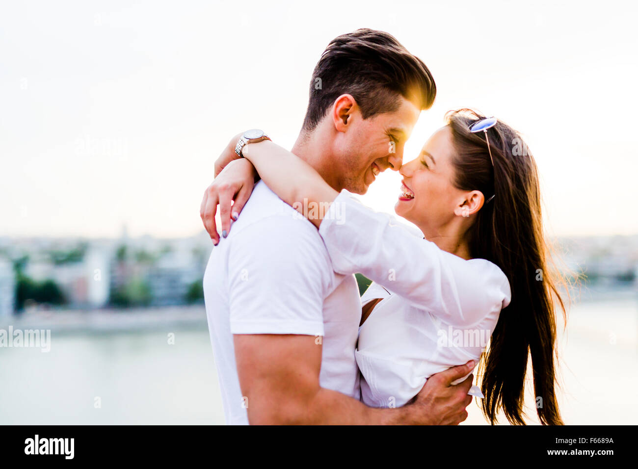 Young romantic couple hugging and about to kiss in beautiful sunset Stock Photo