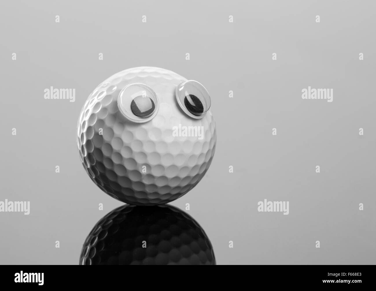 Golf ball with eyes on grey background Stock Photo Alamy