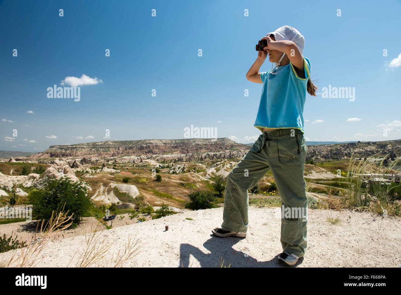 Small girl with binocular in mountains Stock Photo