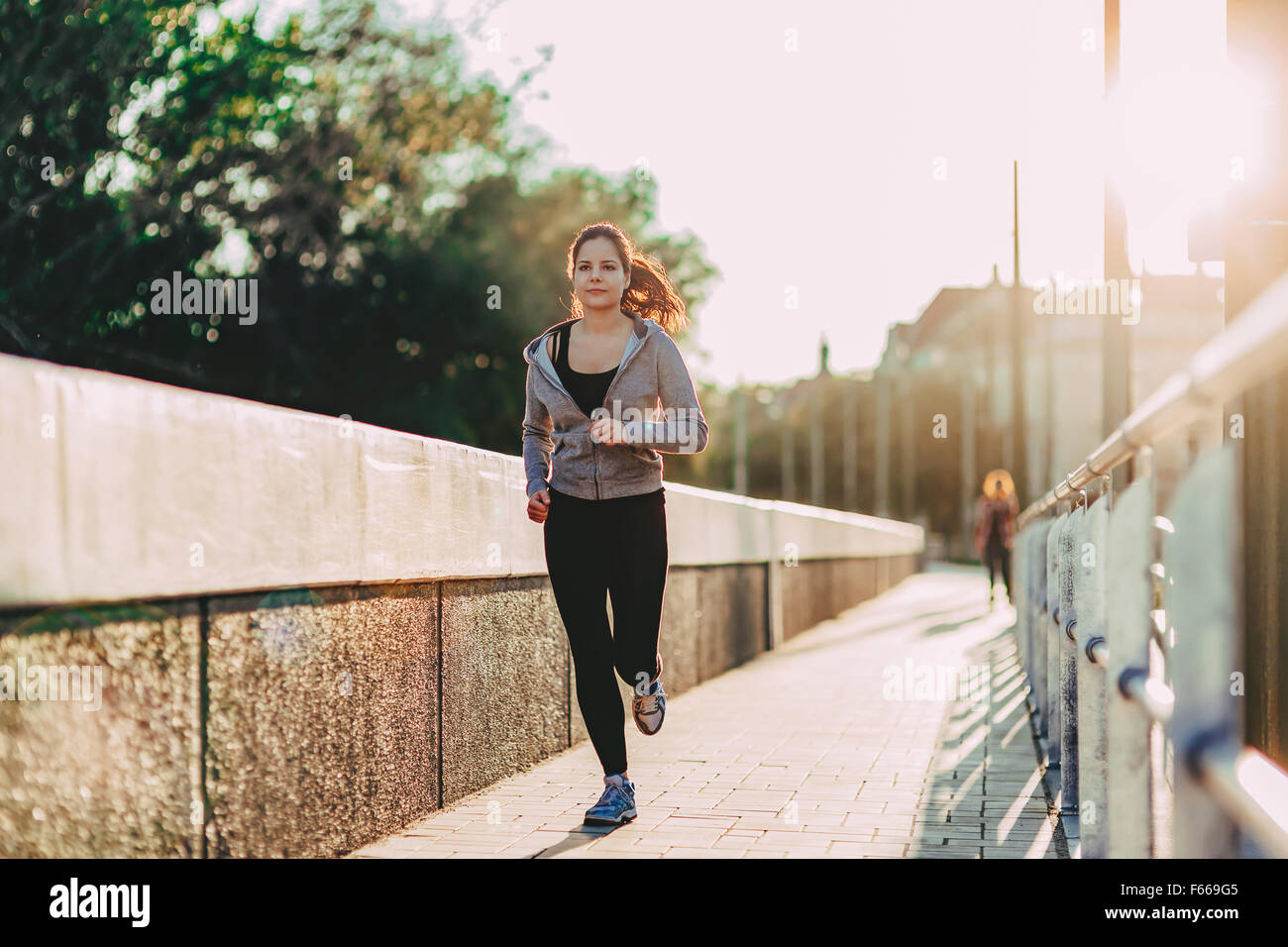 Fit woman jogging in city in beautiful sunset Stock Photo