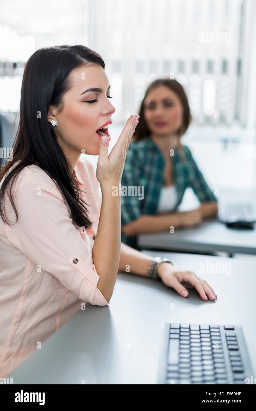 Young beautiful girl yawning during class from boredom and fatigue Stock Photo