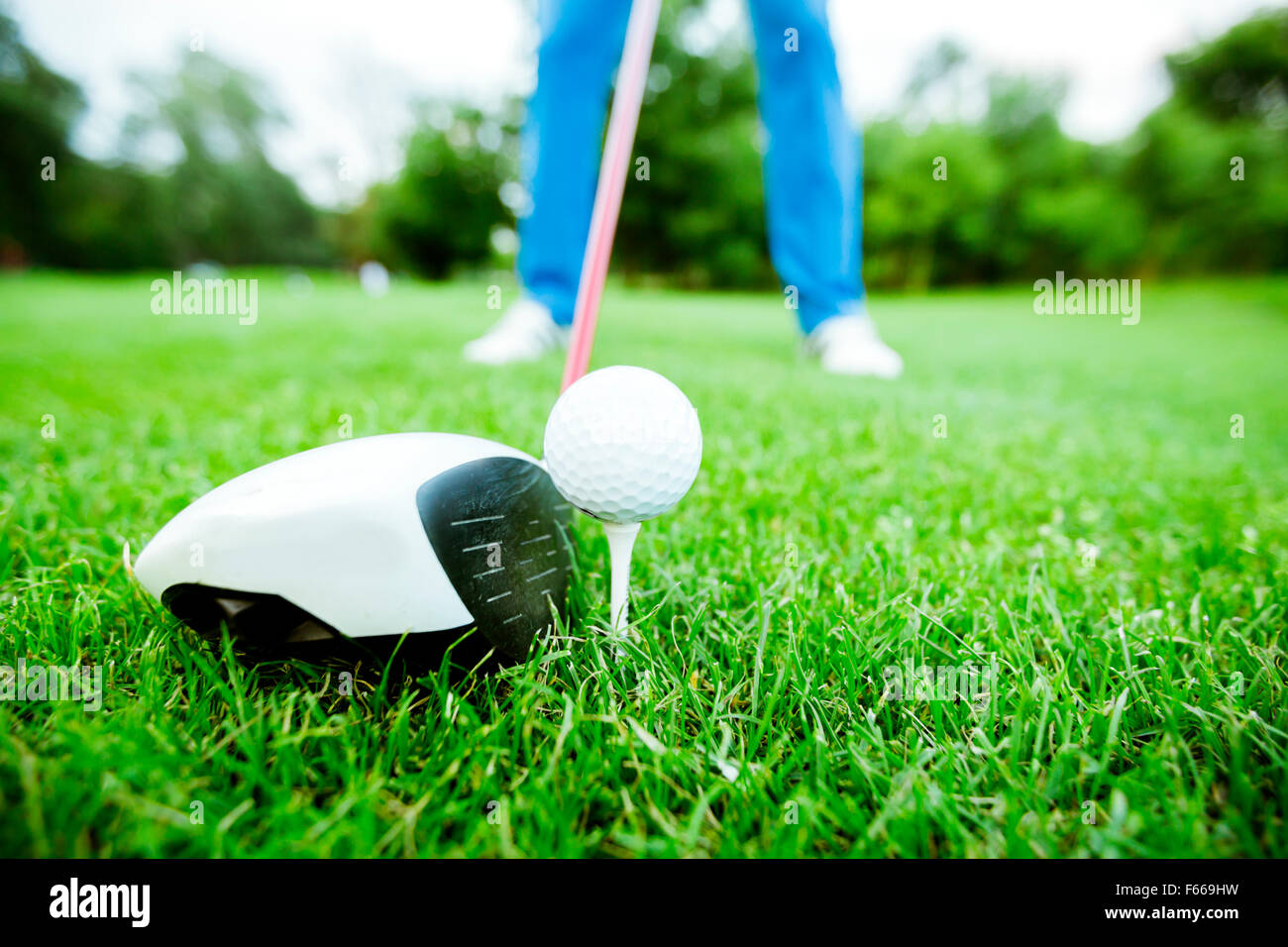 Golfer getting ready to take a shot. Wide angle photo and closeup Stock Photo