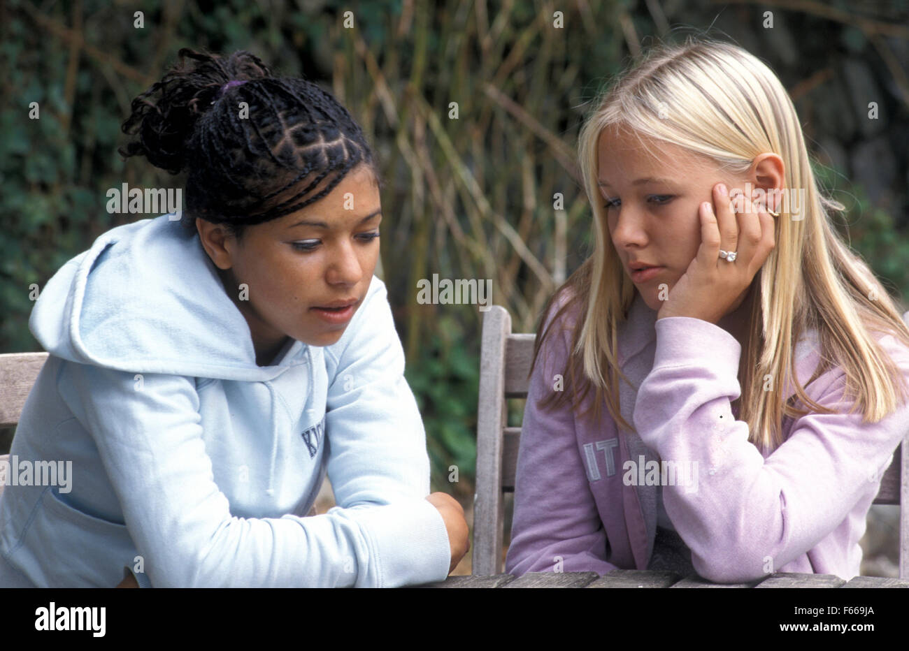 two teenage girls at a park talking Stock Photo