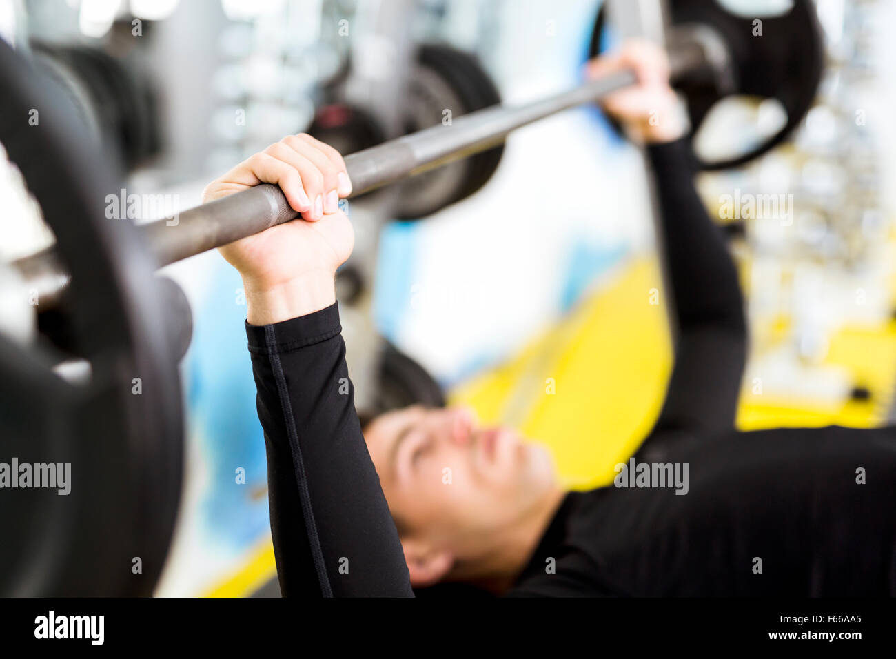 Closeup of young handsome male doing exercises on a bench press Stock Photo
