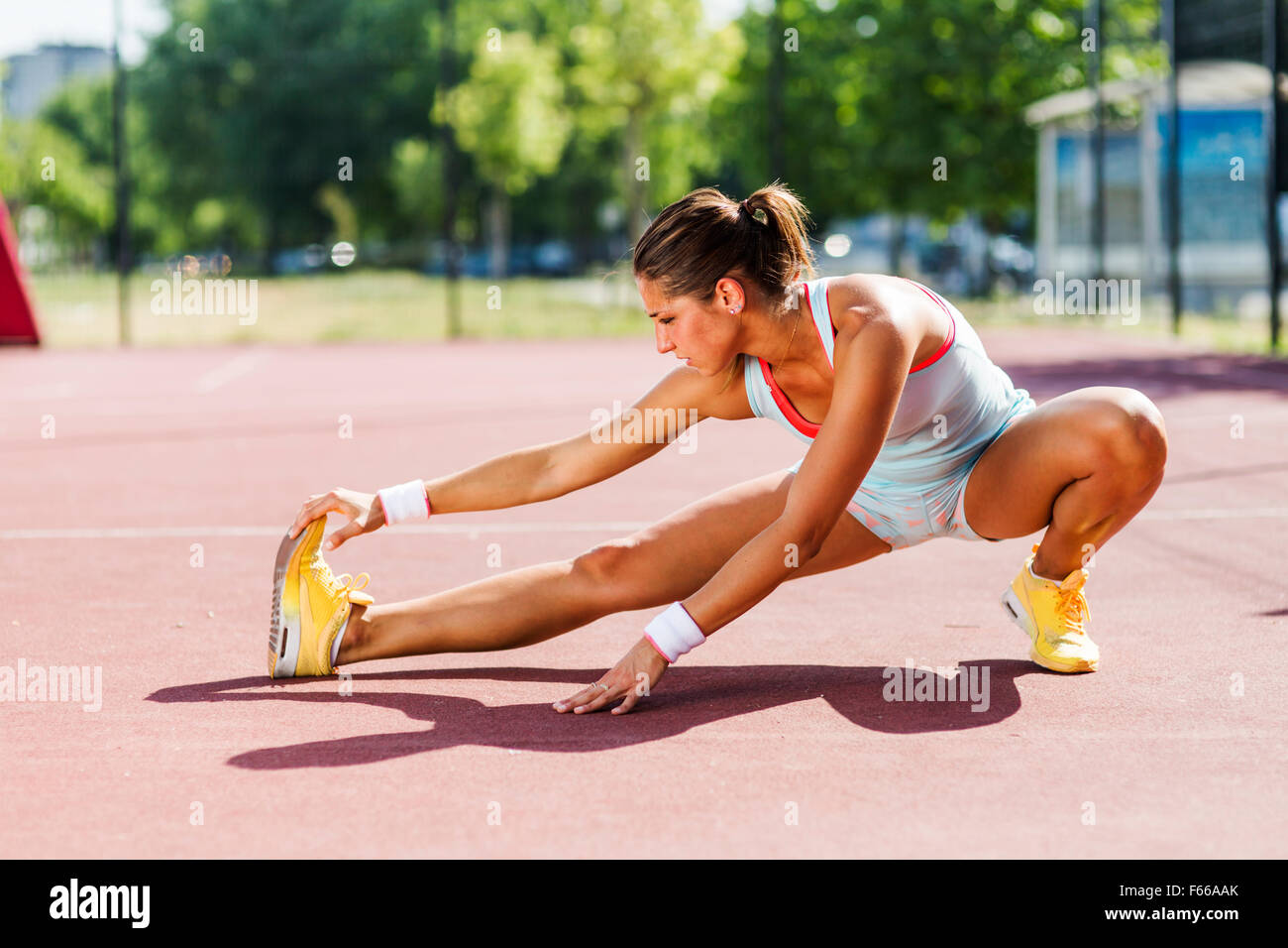 Beautiful young athletic woman stretching in summer before running Stock Photo
