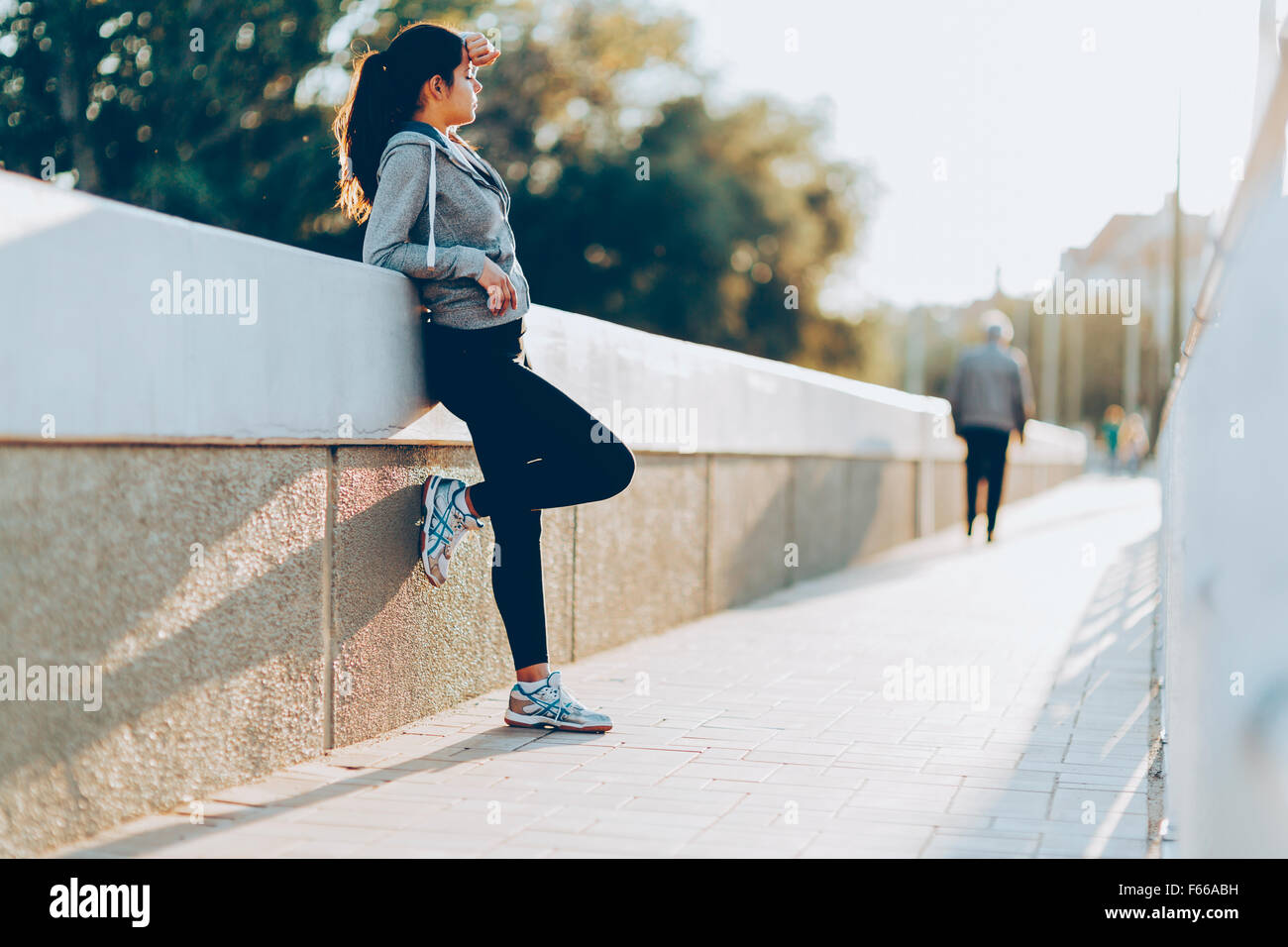 Beautiful woman resting after jogging in city Stock Photo
