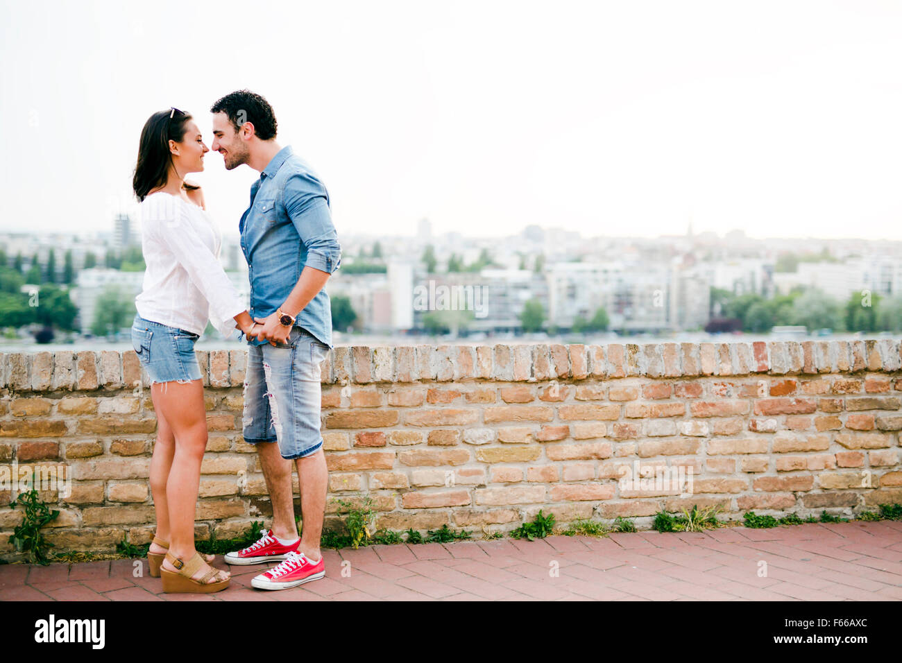 Young and beautiful couple in love being close to each other outdoors and about to kiss Stock Photo