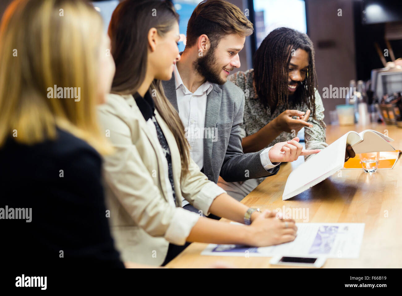 Group of people discussing the contents of the article while sitting in a bar Stock Photo