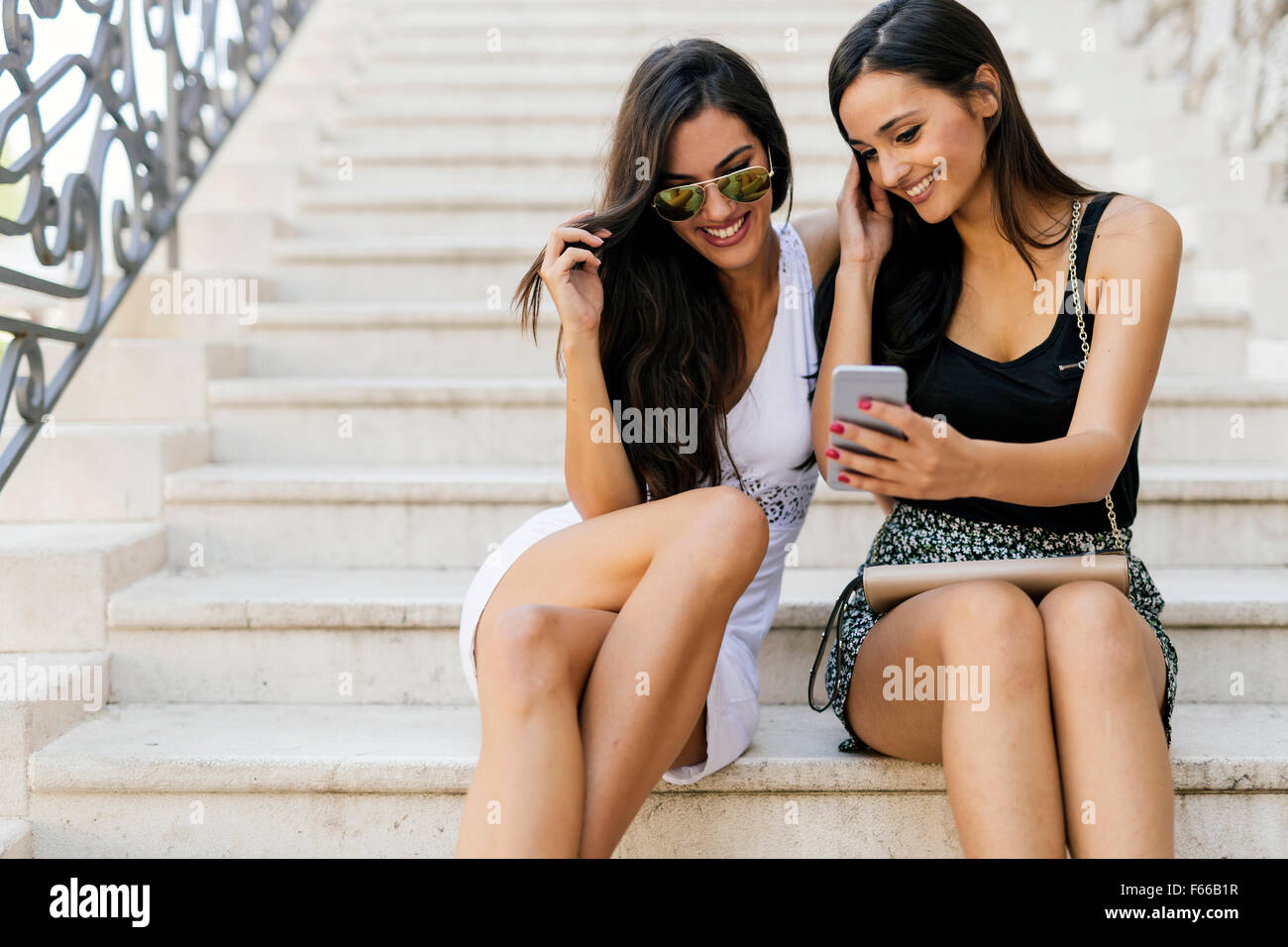 Beautiful women looking at phone and smiling while reading the contents Stock Photo