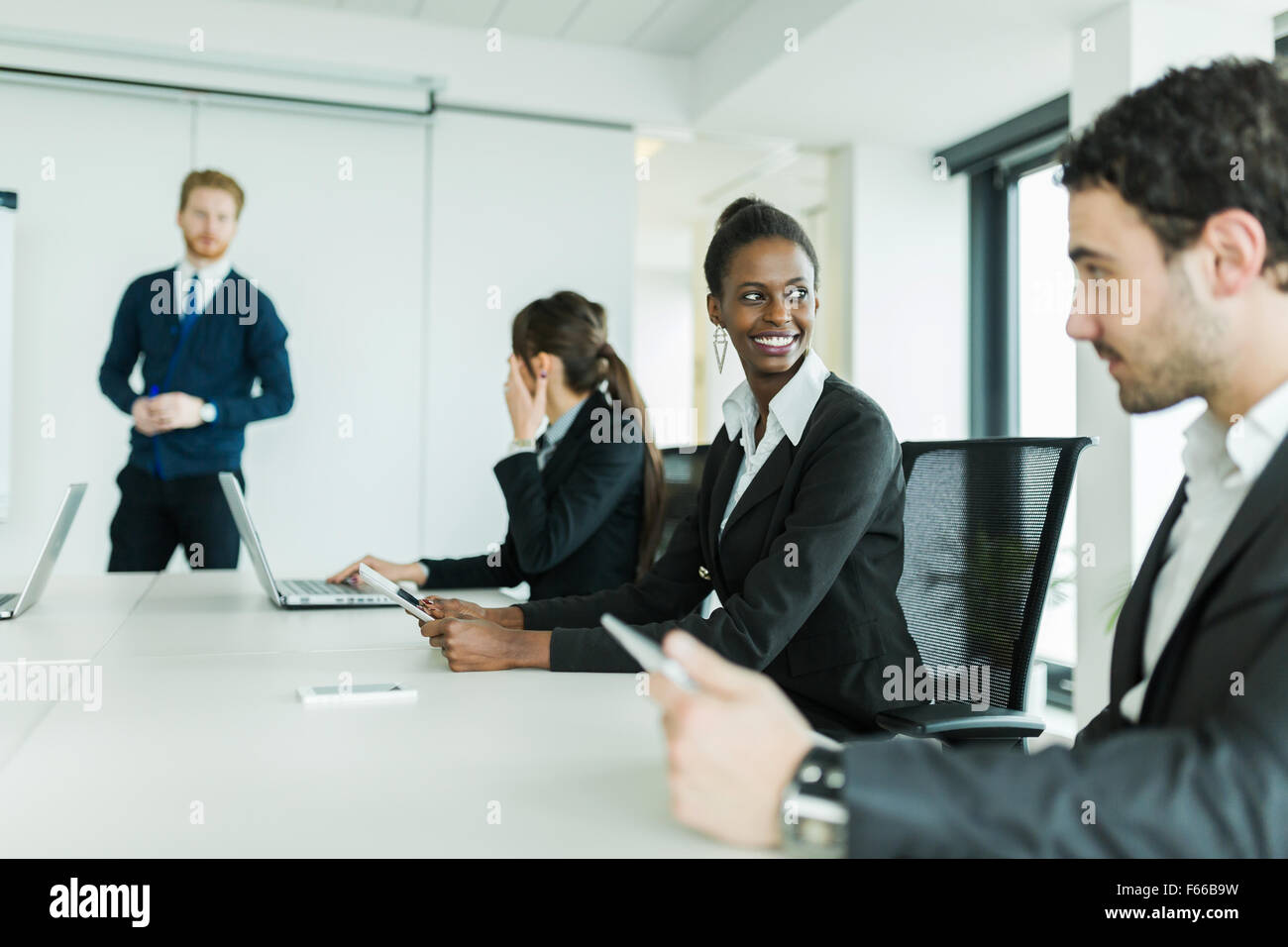 Young business people sitting at a conference table while listening to the lecturer  and learning new technologies Stock Photo