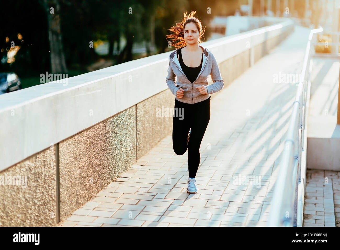 Beautiful female jogging in city and keeping her body in shape Stock