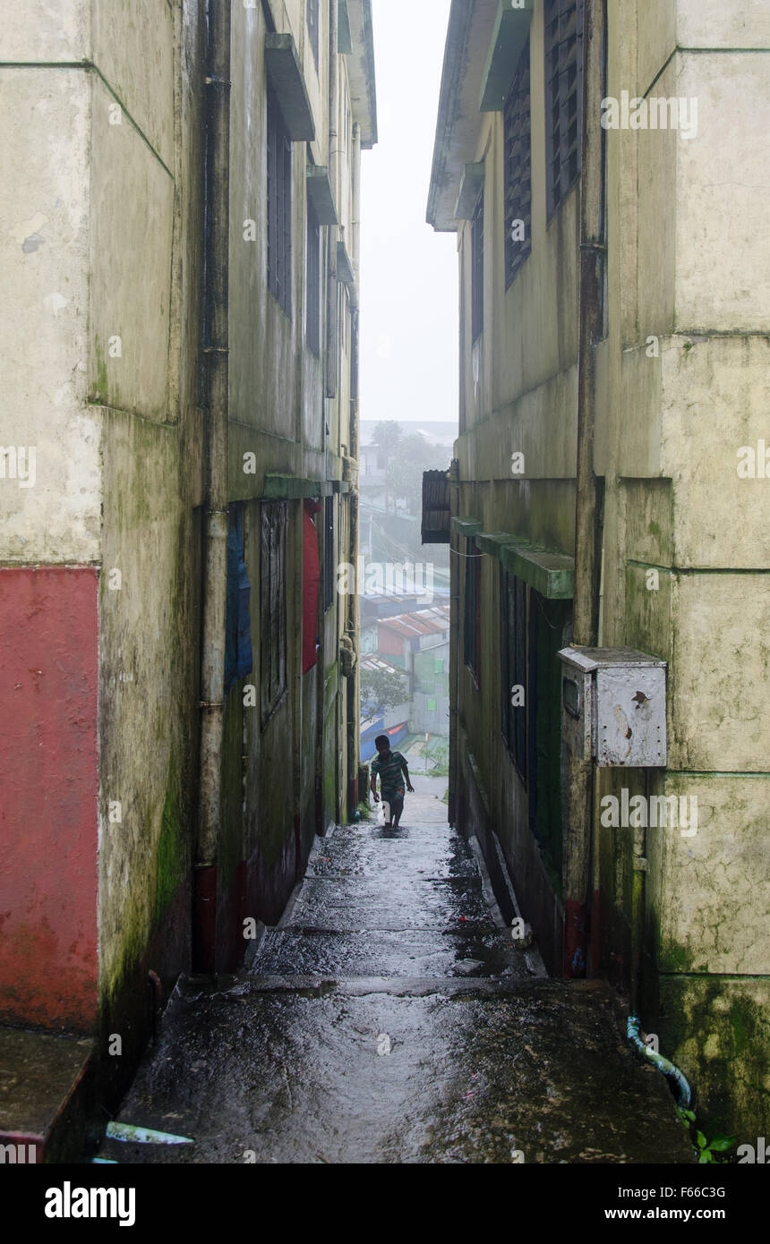 Child exploring city in alley way between high rise derelict buildings ...