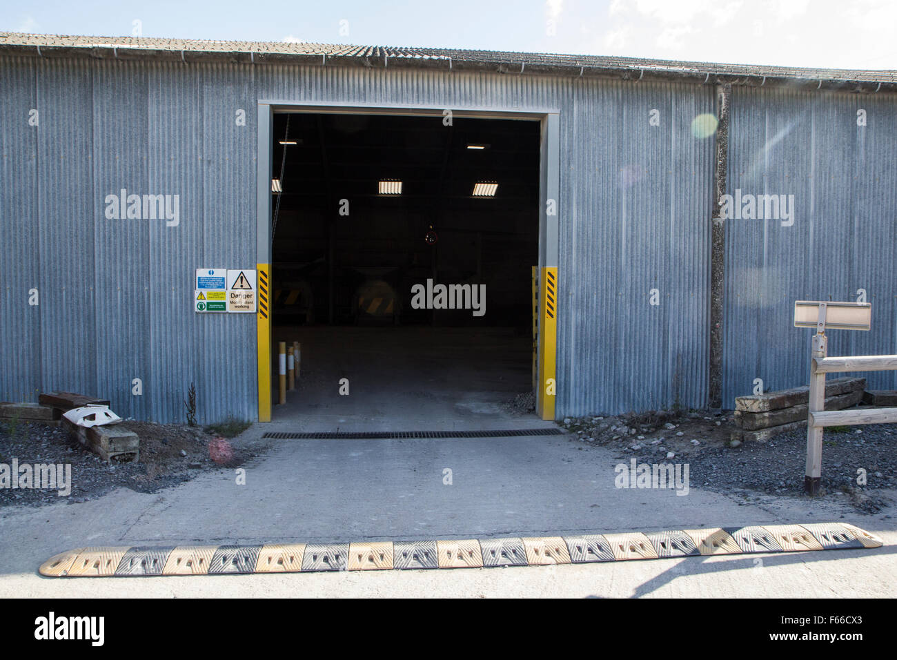 A process site doorway at a quarry with a speed ramp and warning markers Stock Photo