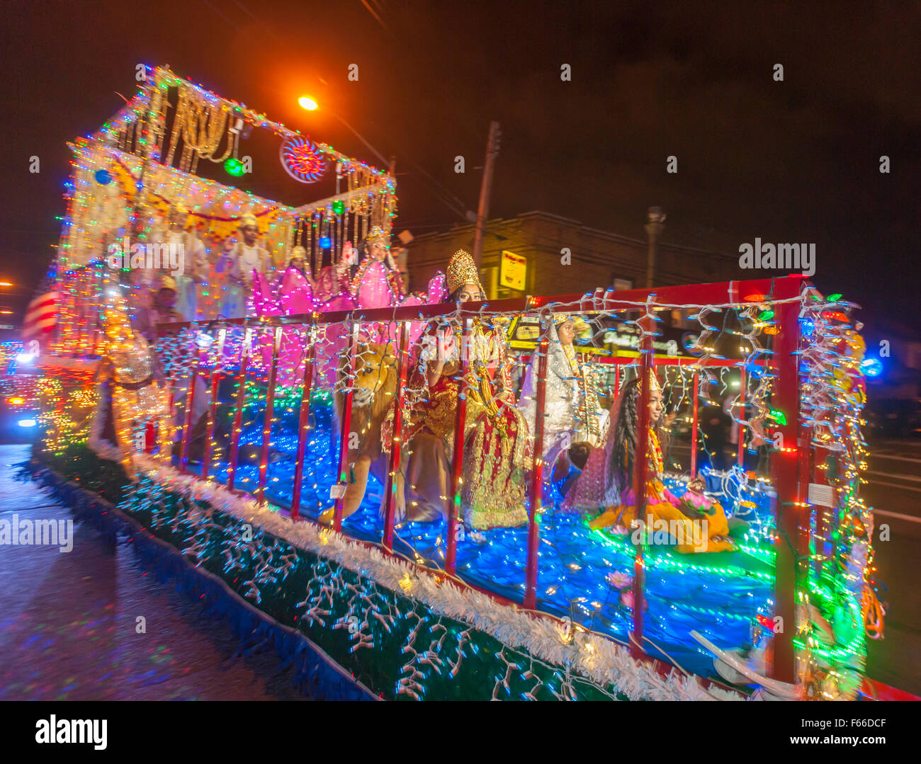 Cars and floats festooned with lights parade down Liberty Avenue in the