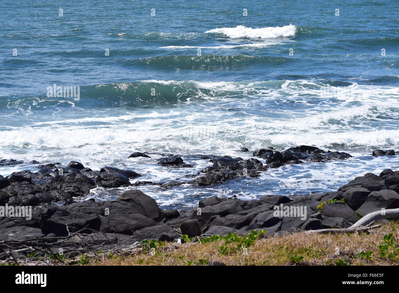 Rocky landscape photo with waves rolling in from the ocean in Australia's sunshine state, Queenland. Stock Photo
