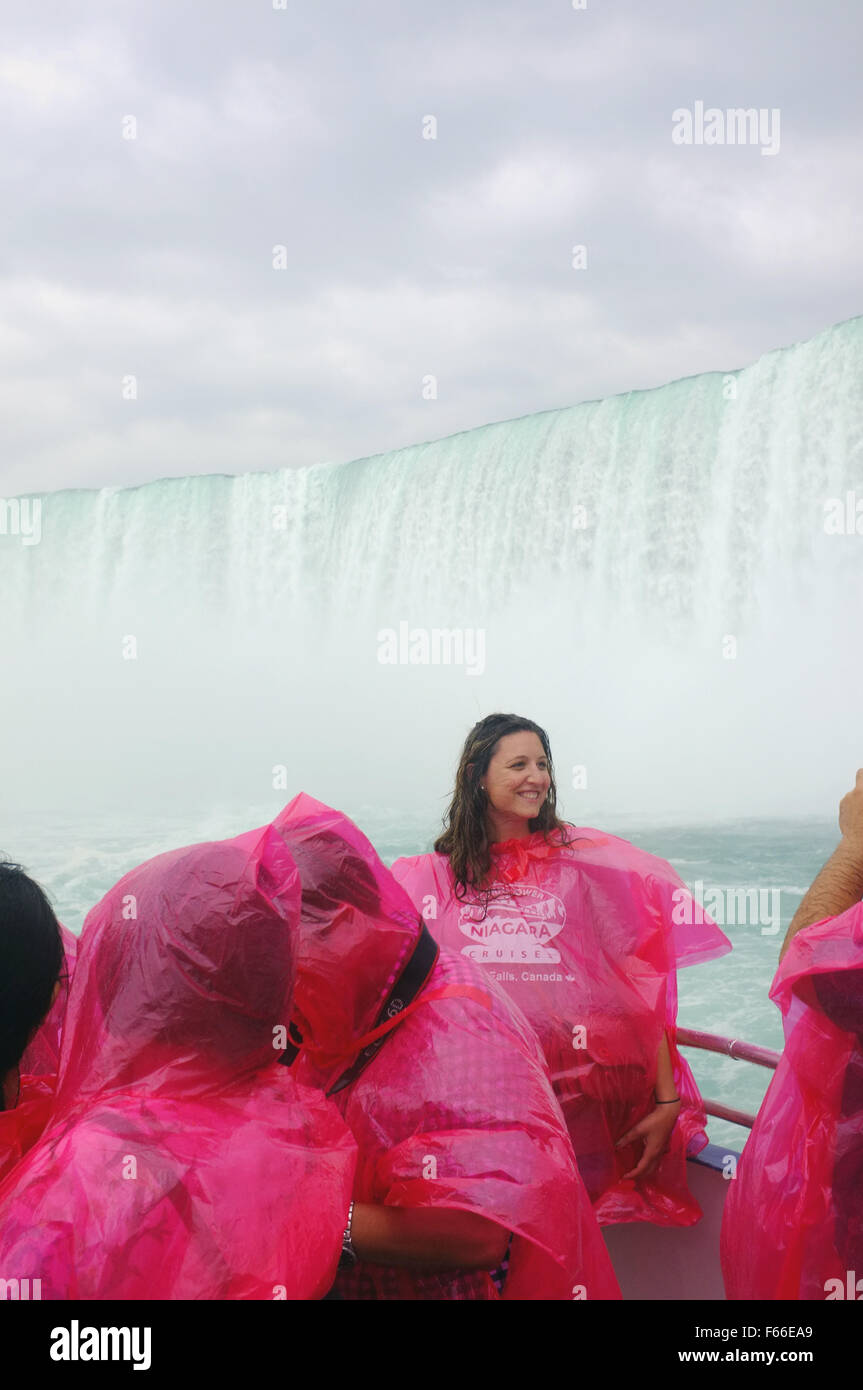 A tourist poses for a photograph while onboard the Hornblower boat which sails up to the Niagara Falls in Ontario. Stock Photo