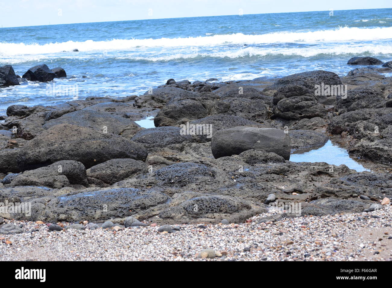 Waves crashing onto rocks at the beach, Bundaberg, Queensland, Australia Stock Photo