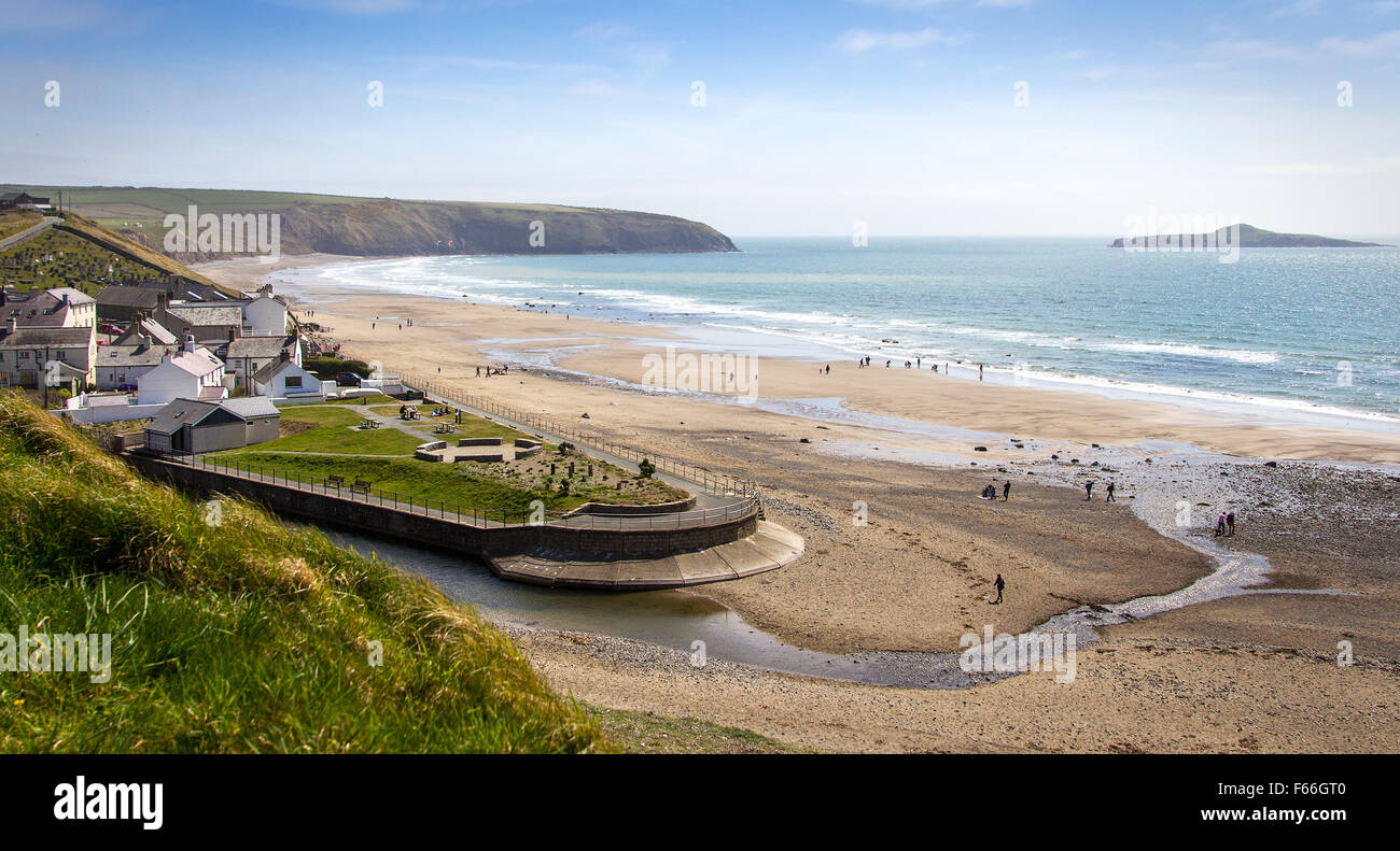 Picture postcard view of a coastal village by the seaside with holidaymakers on the beach Stock Photo