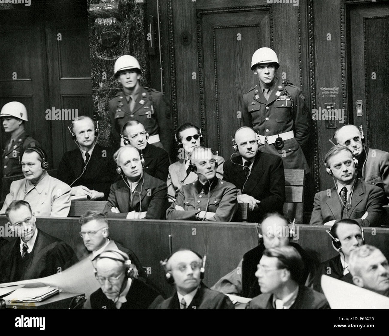 Nuremberg Trials defendants photographed in the dock, in two rows. Front row, left to right: Hermann Goering, Joachim von Ribbentrop, Wilhelm Keitel, and Alfred Rosenberg. Back row, left to right: Karl Doenitz, Erich Raeder, Baldur von Schirach, Fritz Sauckel, and Alfred Jodl. Stock Photo