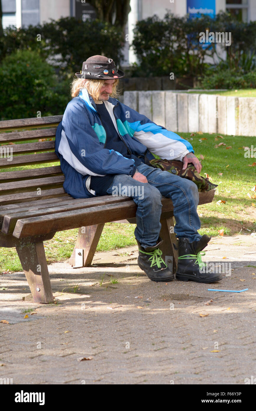 Homeless man sitting on bench in Plymouth city centre in Devon, England ...