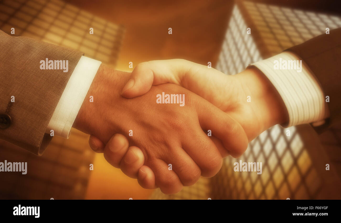 business accounting balance. Handshake with modern skyscrapers as background. Stock Photo