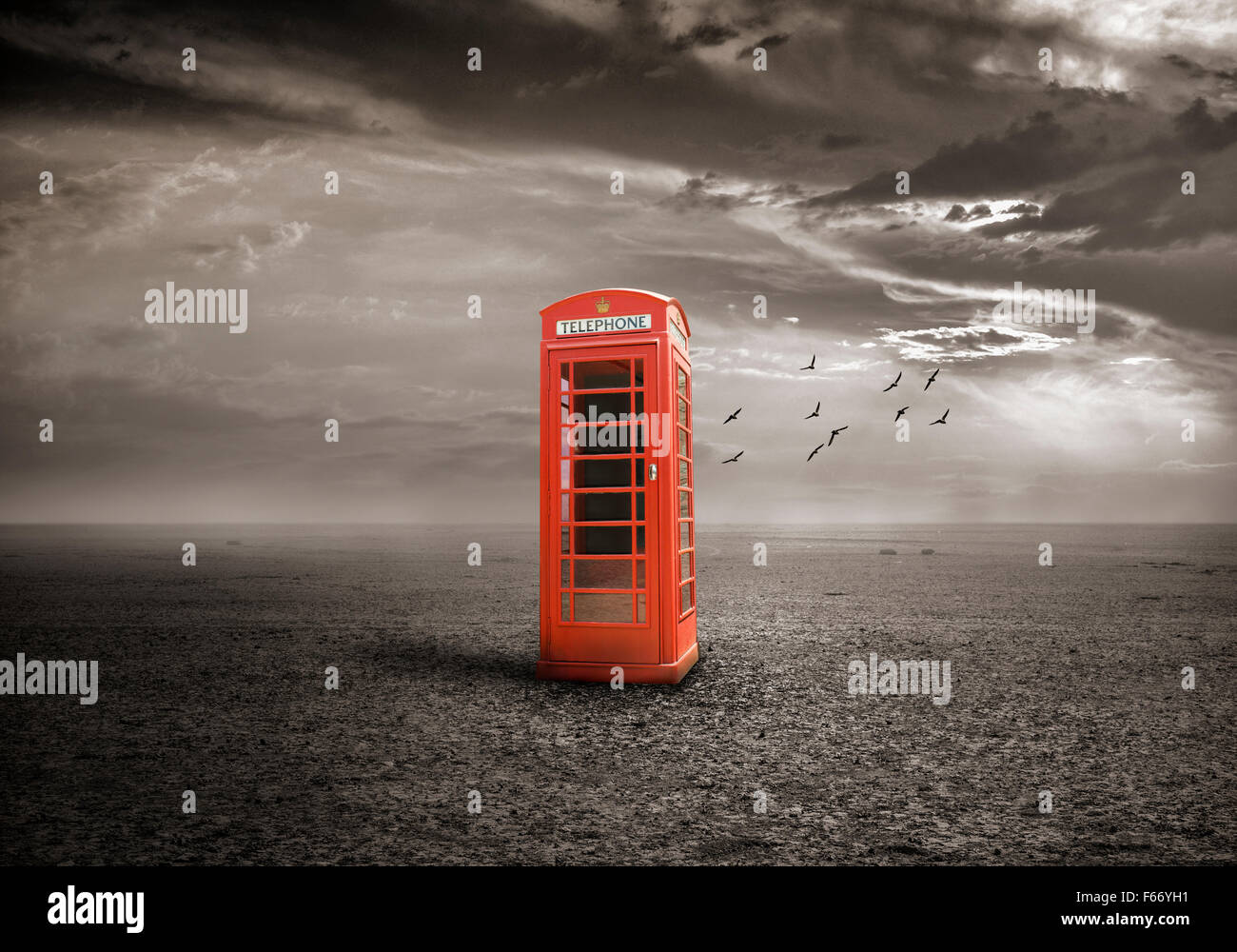 Old-fashioned traditional red telephone booth on deserted field Stock Photo