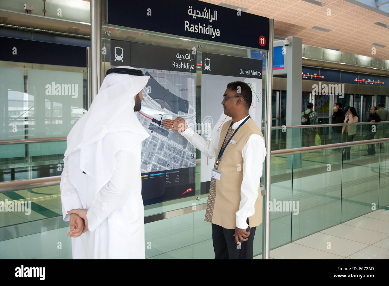 Arab man being given information from staff member of the Dubai Metro Stock Photo