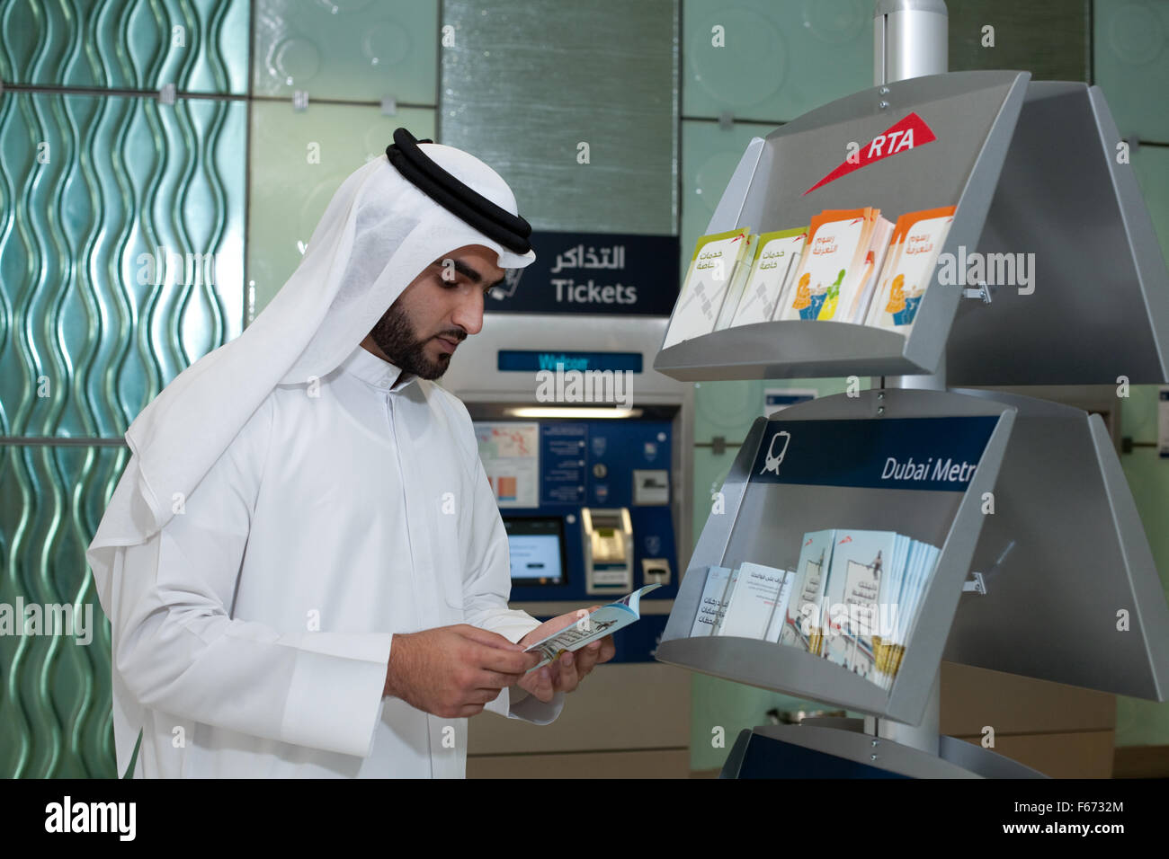 Arab man in Dubai Metro ticket foyer looking at leaflets Stock Photo