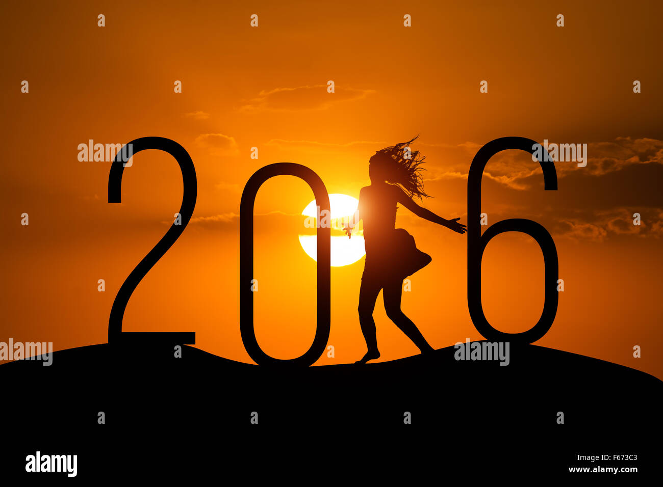 Silhouette woman jumping over 2016 on the hill at sunset Stock Photo