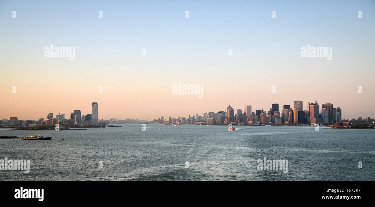 Jersey City and Downtown Manhattan viewed from the Upper New York Bay at sunset in New York City, USA. Stock Photo
