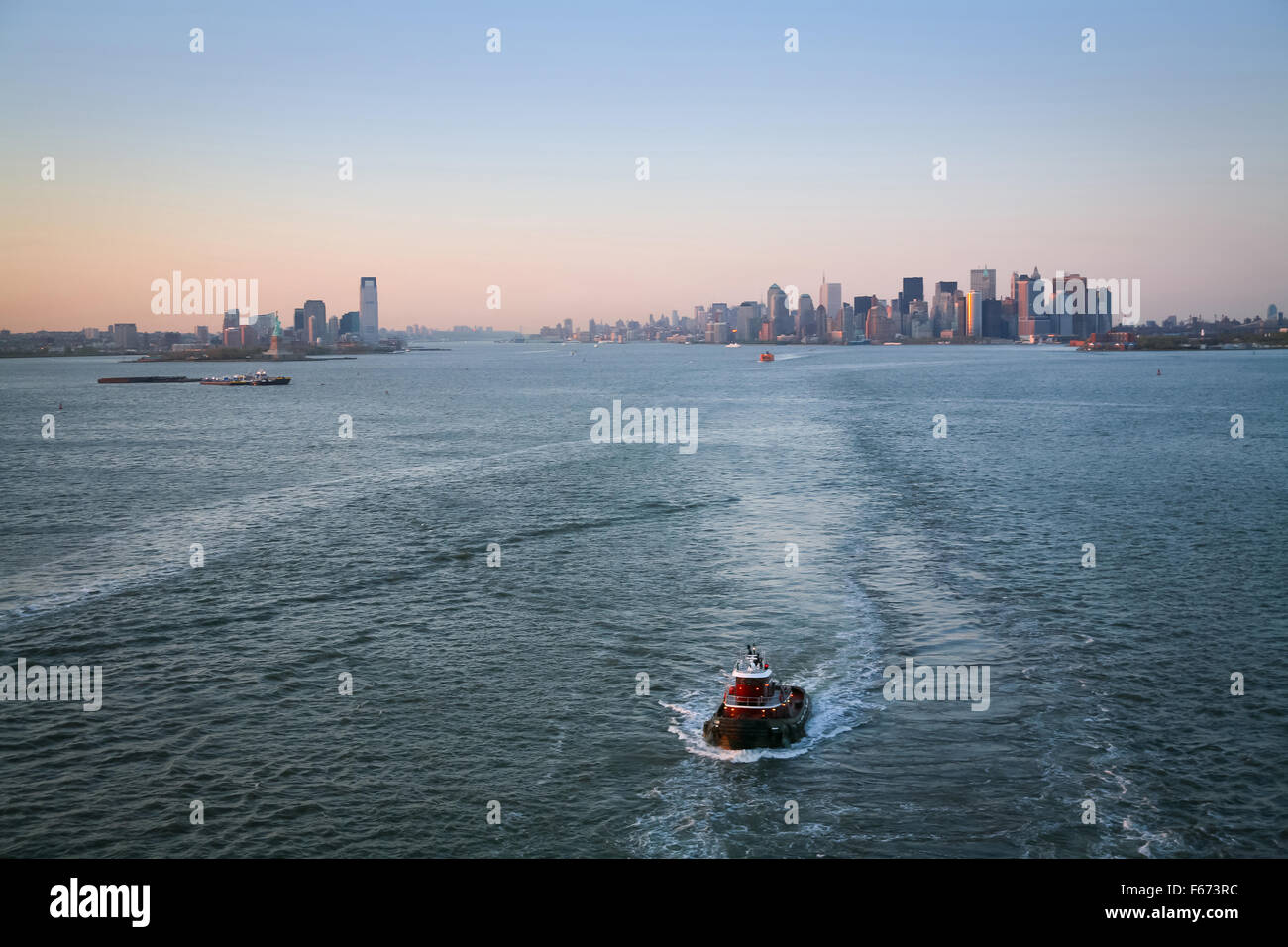 A tugboat sailing in the Upper New York Bay with Jersey City and
