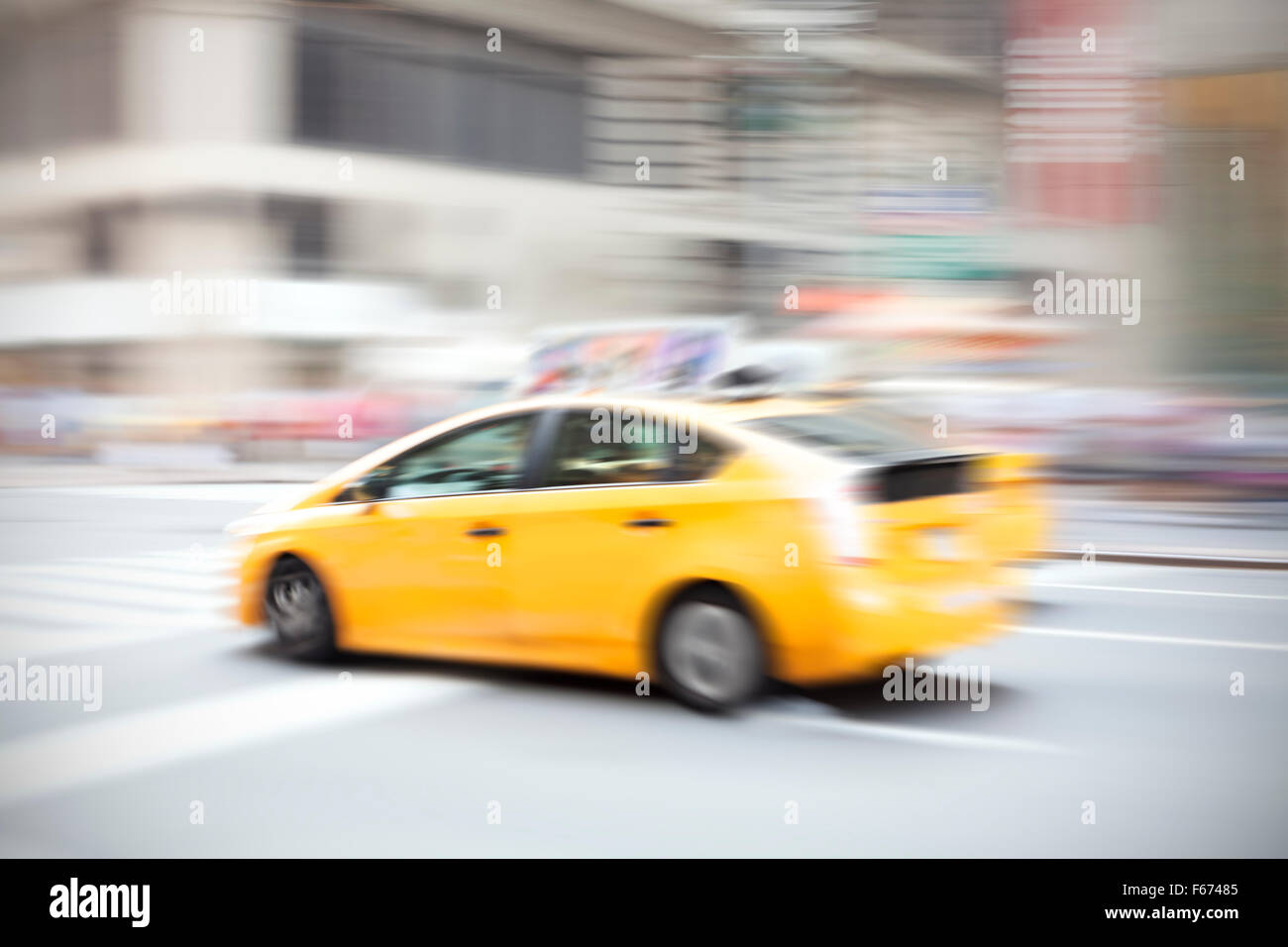 Motion blurred yellow taxi on a city street. Stock Photo