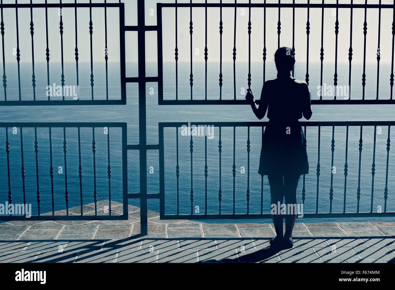 woman  watching sea  ,dramatic view,woman on the edge ,woman silhouette unusual Stock Photo