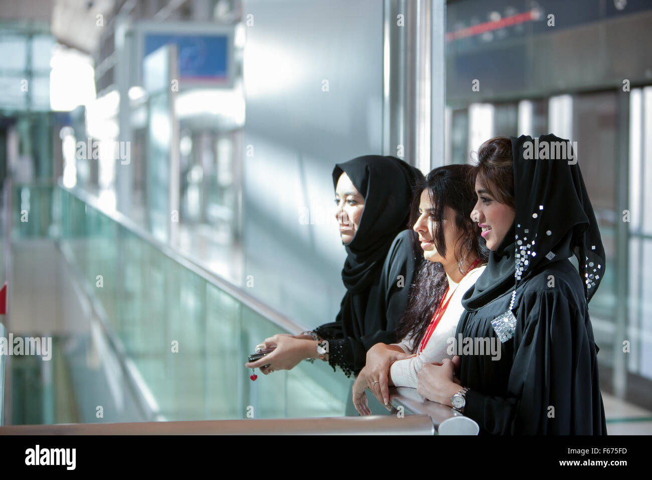 3 Arab ladies chatting on platform of the Dubai Metro Stock Photo