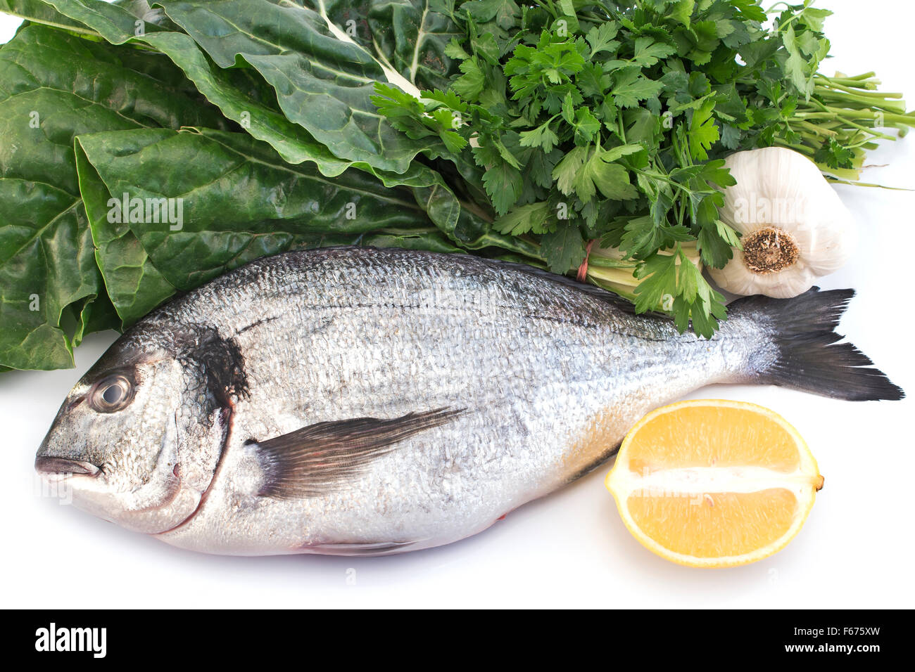 Fish dorade with swiss chard, parsley, garlic and lemon. Stock Photo