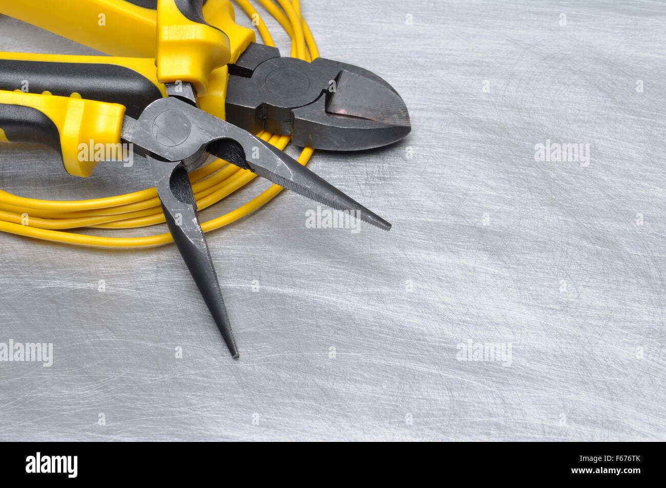 Yellow electrical tools and cables on metal surface with place for text ...
