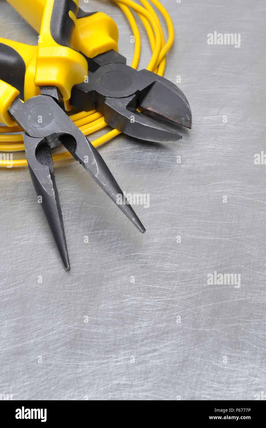 Yellow electrical tools and cables on metal surface with place for text ...