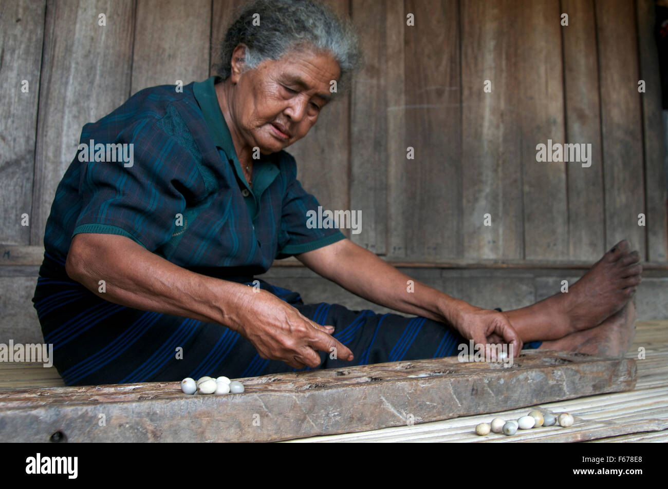Woman playing the traditional game congkak Stock Photo