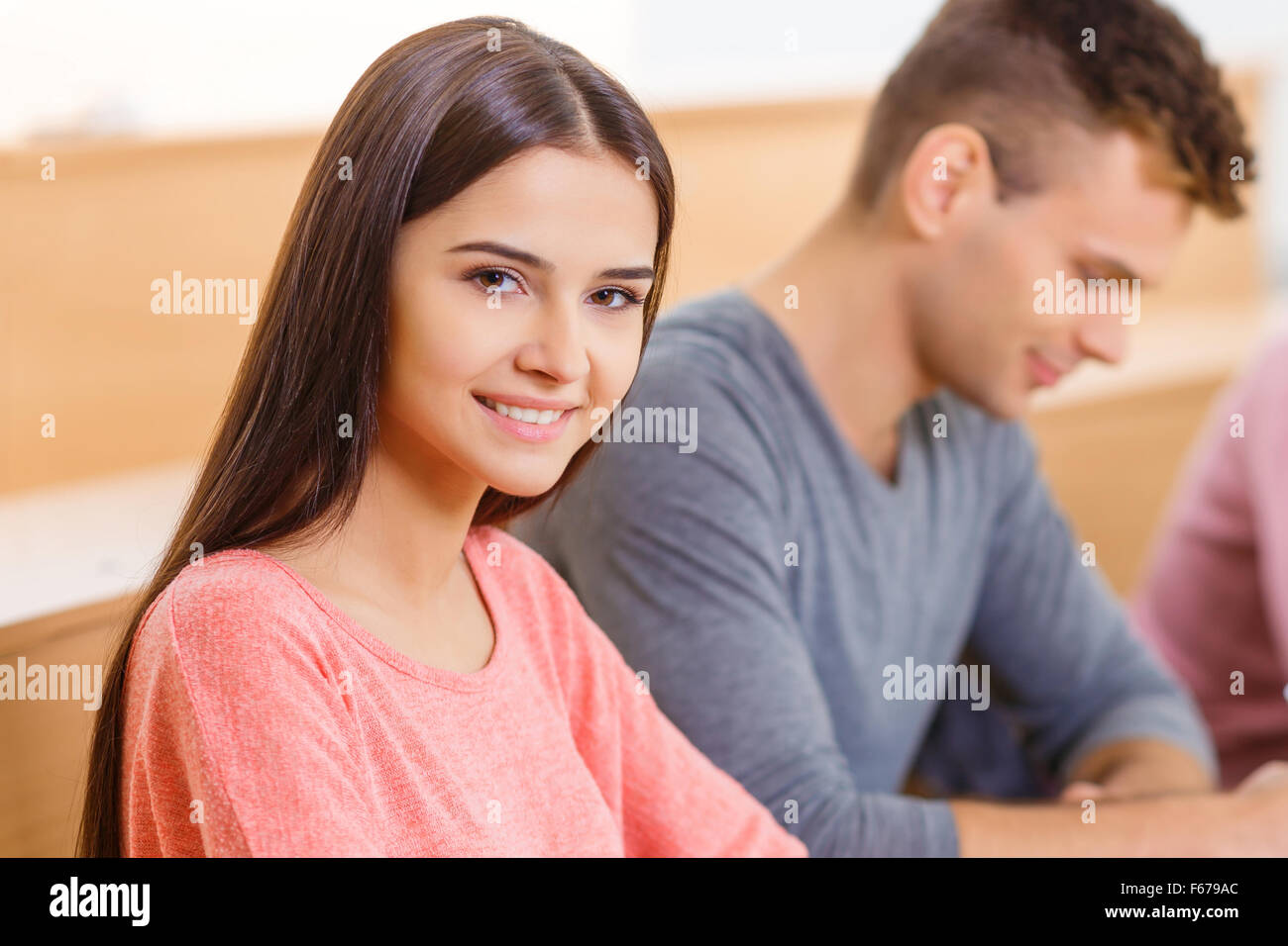 Young smiling girl is sitting at the desk Stock Photo - Alamy