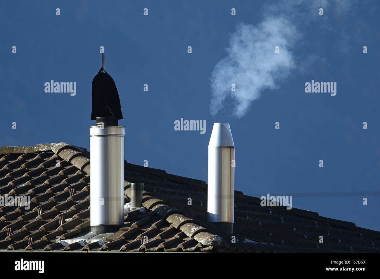 Heating oil going into the air from a filtered stack on a roof Stock Photo