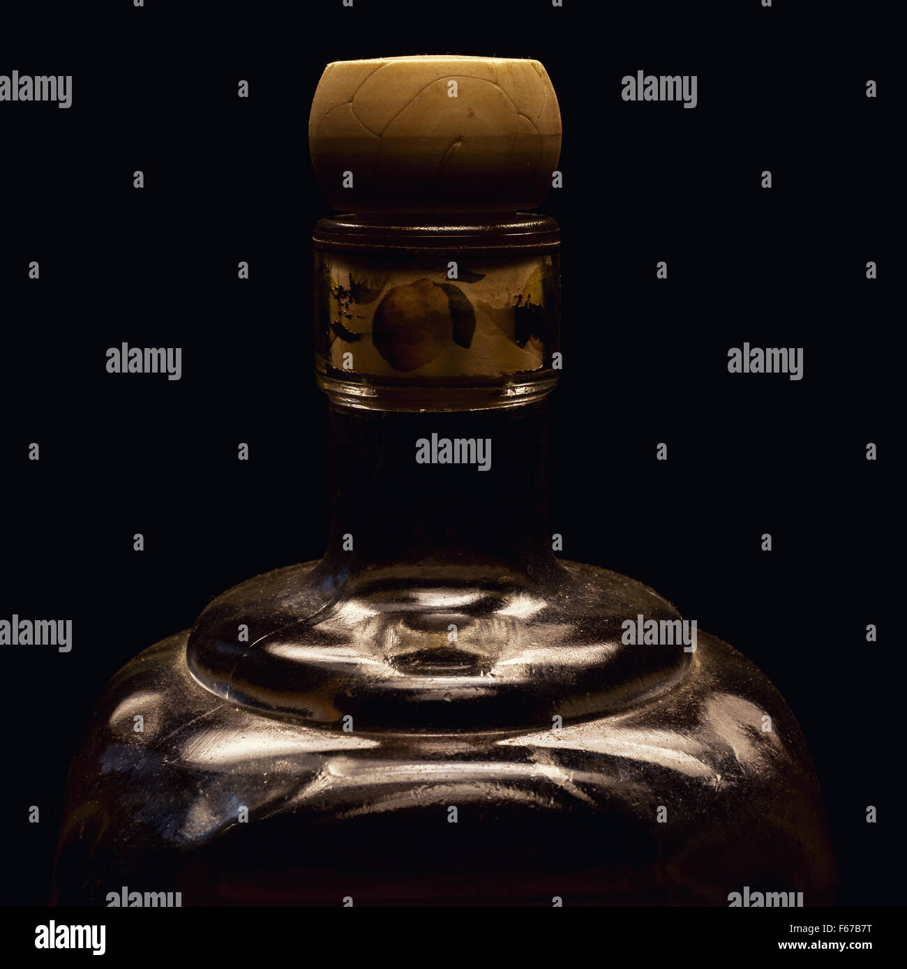 One part of an old spirit bottle, accentuated shapes with light, on black background. Stock Photo
