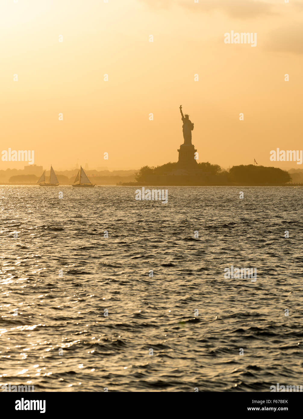 Statue of Liberty before sunset in hazy New York Harbor Stock Photo