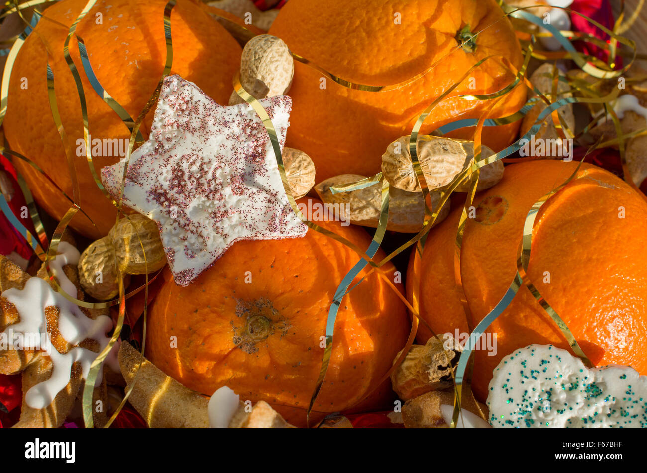 Christmas Still with Oranges Peanuts and Star Decoration Covered with Angel Hair Closeup Stock Photo