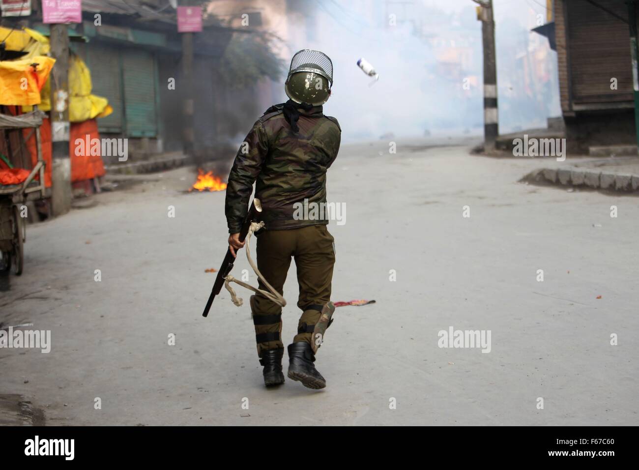 (151113) -- SRINAGAR, Nov. 13, 2015 (Xinhua) -- An Indian policeman throws a stun shell at Kashmiri protesters during a protest in Srinagar, summer capital of Indian-controlled Kashmir, Nov. 13, 2015. Indian police fired dozens of tear smoke shells and rubber bullets as they clashed with Kashmiri protesters during a protest following Friday congregation prayers against the killing of 22-year-old student Gowhar Nazir Dar in firing incident by Indian paramilitary troopers. The protest call was given by hard-line Kashmiri separatist leader Syed Ali Shah Geelani. (Xinhua/Javed Dar) (zjy) Stock Photo